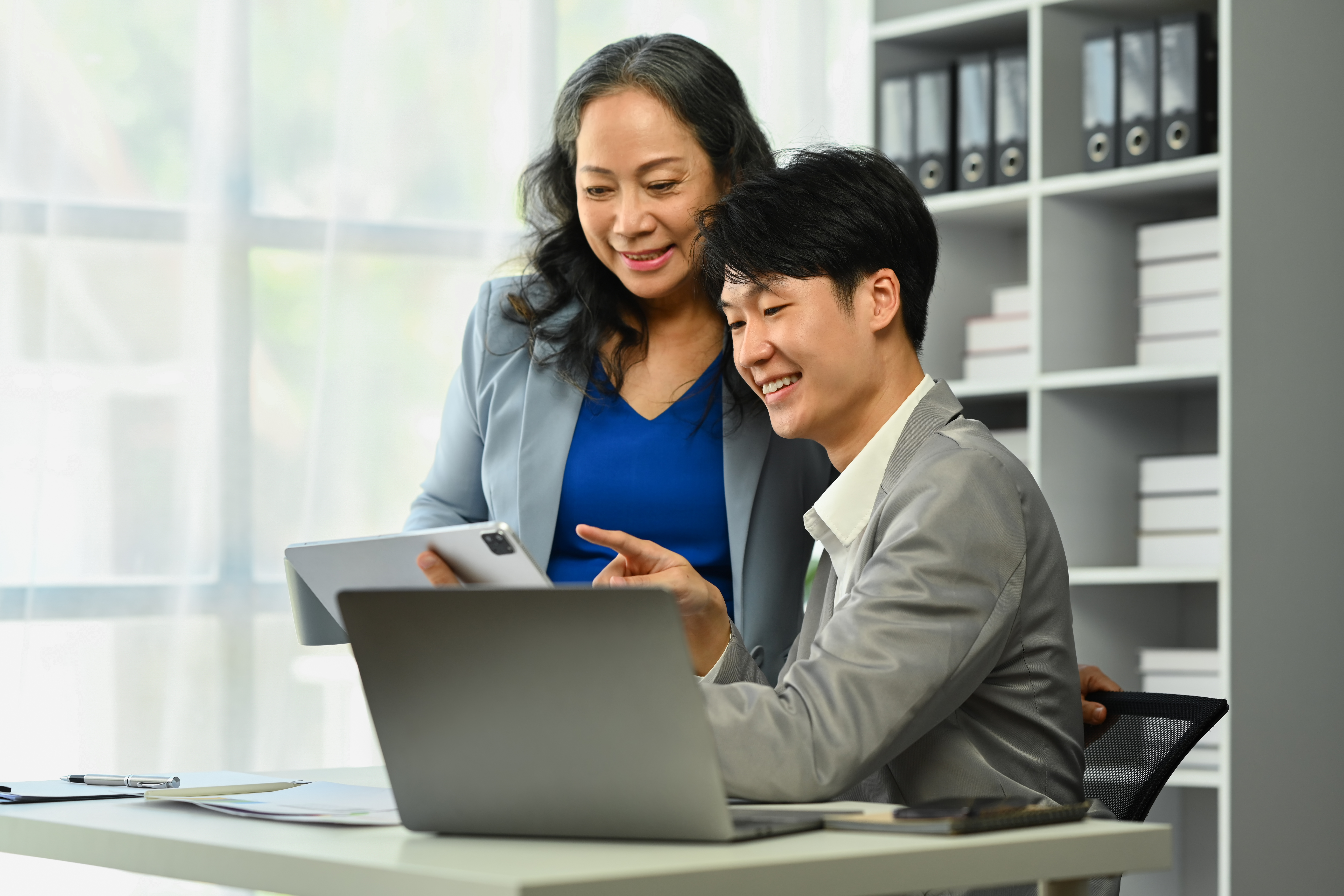 Woman talking to a man with a laptop