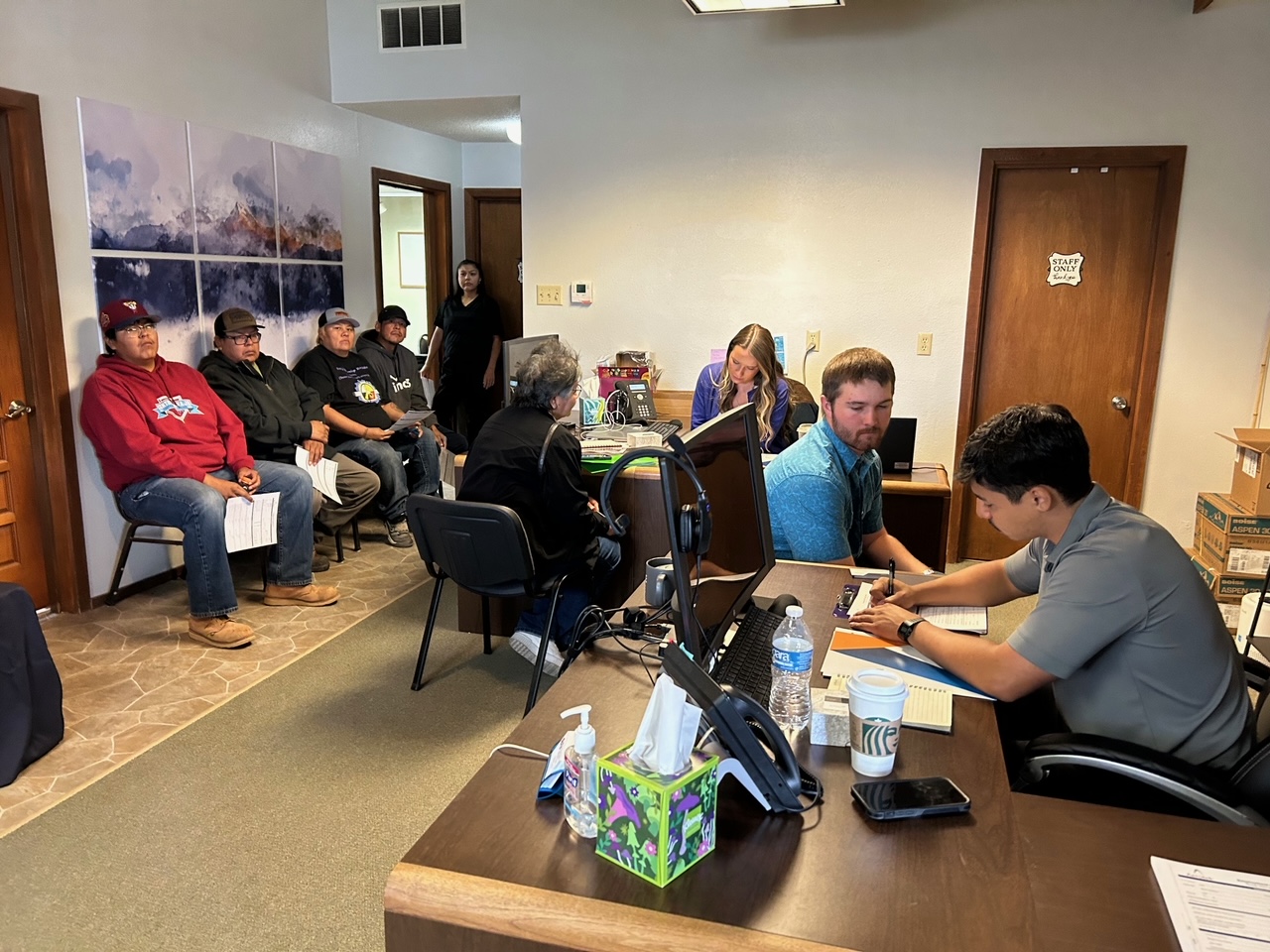 Group of individuals being assisted by office workers at a workforce center