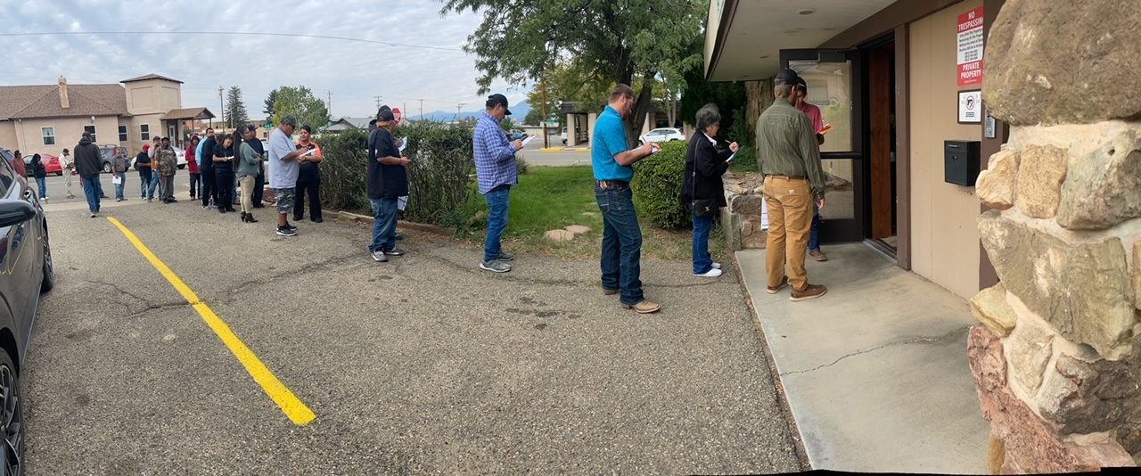 Wide view of diverse group of people lining up to a workforce center in a rural community